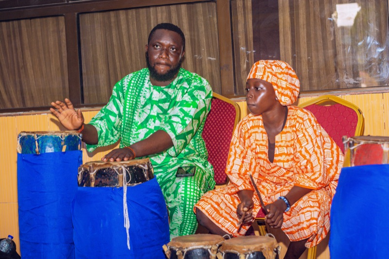 Two drummers in traditional attire playing drums