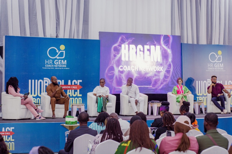 Panellists seated on white chairs on the Workplace Transformation stage