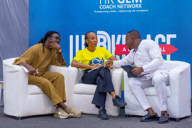 Three speakers in a coaching conversation on stage at the 2026 event